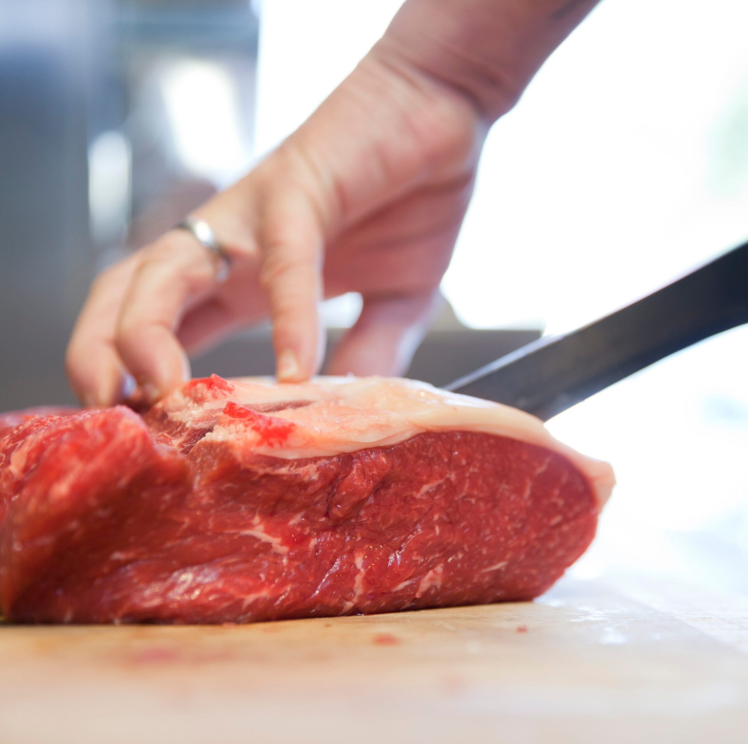 close-up-of-butchers-hands-slicing-raw-steak-on-royalty-free-image-602922519-1551051976-5832293