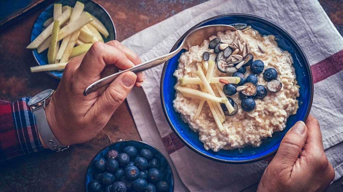 man-eating-oatmeal-blueberries-apples-1296x728-6450696