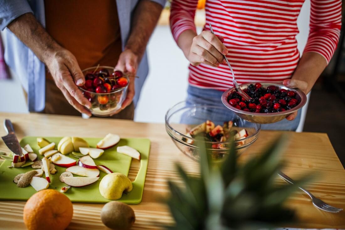 people-making-a-fruit-salad-in-kitchen-using-berries-and-apples-for-whole30-diet-9698281
