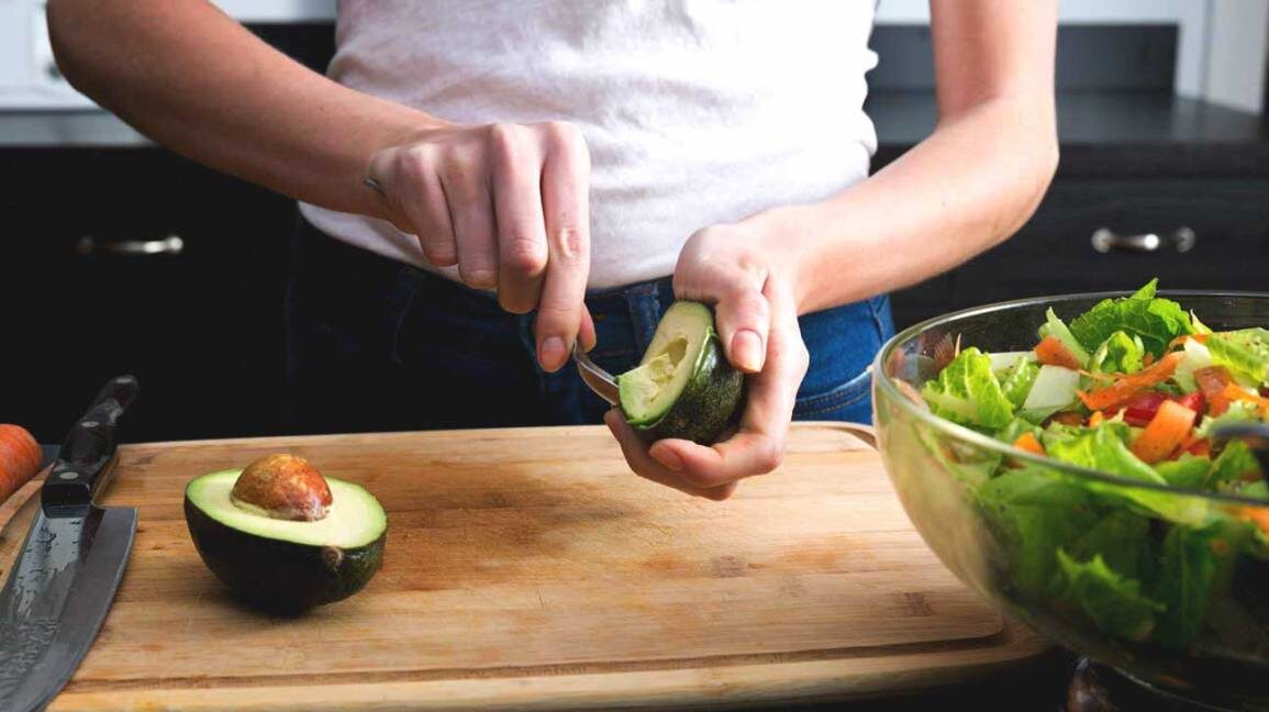woman-scooping-avocado-into-salad-1296x728-1720503